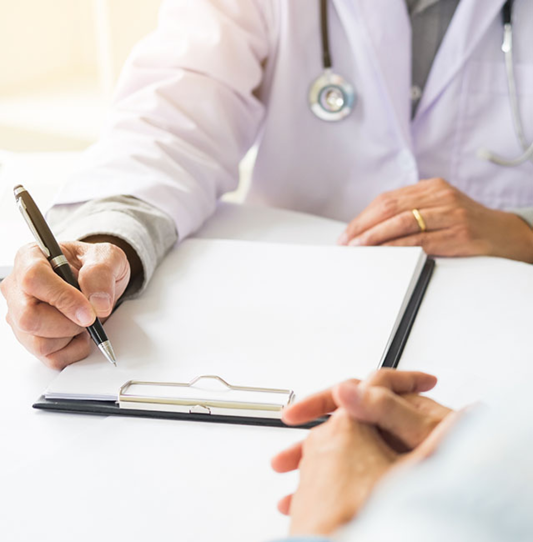 Ein Arzt schreibt Notizen auf einem Klemmbrett in einem medizinischen Umfeld